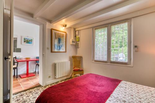 a bedroom with a bed and a table and a window at Villa - Oasis centre charme in Montpellier
