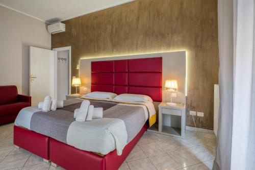 a bedroom with a large bed with a red headboard at Sant'Oronzo House in Lecce