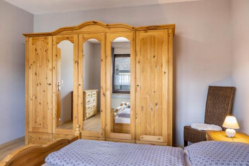 a wooden cabinet in a bedroom with a bed at Ferienwohnung Sonnenschein in Bad Hersfeld