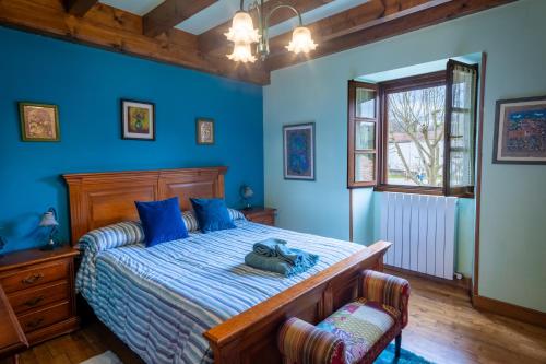 a bedroom with a bed with blue walls and a window at Matxingonea 1 in Urdax