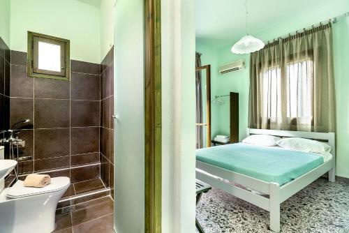 a bedroom with a bed and a bathroom at Old Boat double studio 1 in Nikiana
