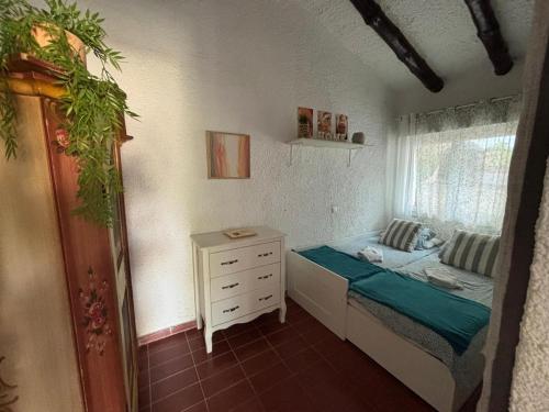 a bedroom with a bed and a dresser and a window at Villa Mediterraneo in Tossa de Mar