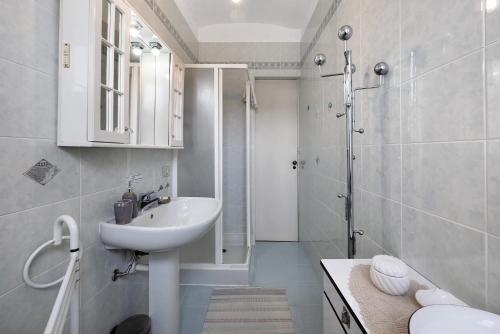 a white bathroom with a sink and a shower at Casa Dello Zio Birba in Portacomaro