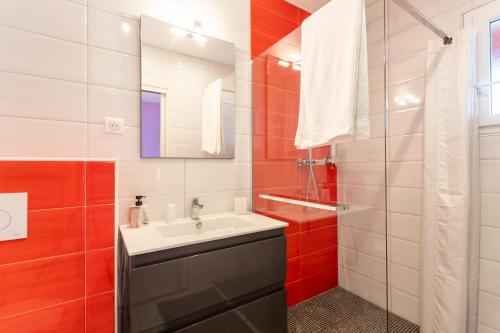 a bathroom with a sink and red and white tiles at Chambre - Orchis in Aroue