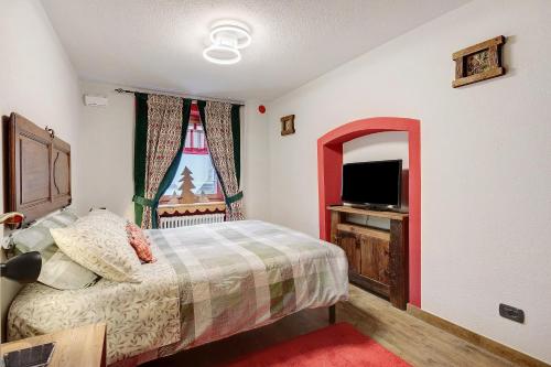 a bedroom with a bed and a tv and a window at Casa Gardenia in Arvier