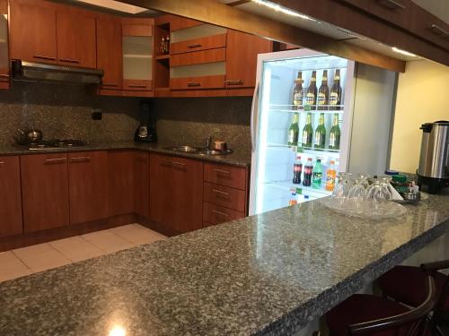 a kitchen with a refrigerator filled with bottles of wine at Kinde House in Quito