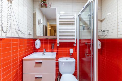 a red bathroom with a toilet and a sink at Pensado Para ti in Pozuelo de Alarcón