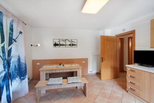 a living room with a table and a tv at Appartamenti Camilla in Canazei