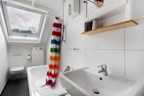 a bathroom with a sink and a toilet and a shower curtain at Zur Stadtmama in Endingen