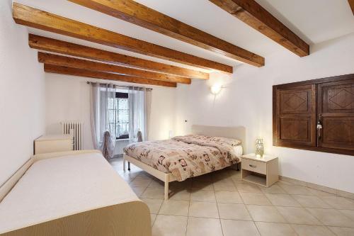 a bedroom with two beds and wooden ceilings at Le Bourg 61 - Aosta Centro in Aosta