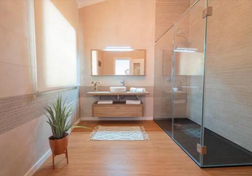 a bathroom with a glass shower and a sink at Quinta da Romã in Olhão