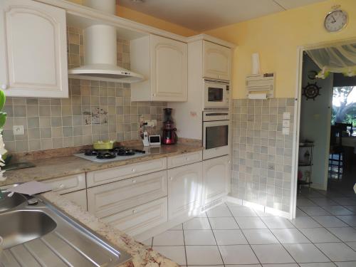a kitchen with white cabinets and a sink at Sweet Home - Gujan-Mestras in Gujan-Mestras