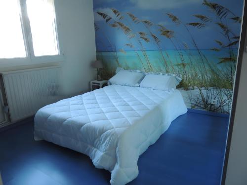 a bedroom with a white bed with a painting on the wall at Sweet Home - Gujan-Mestras in Gujan-Mestras