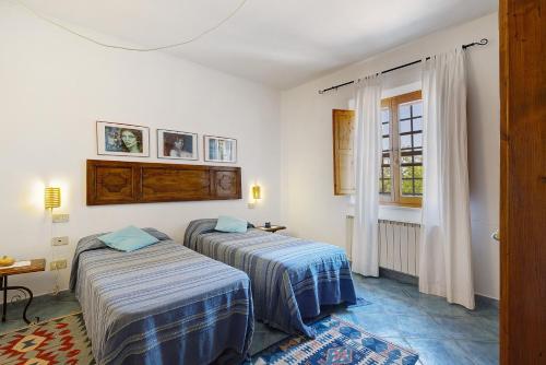 a room with two beds and a window at La Ripa - Appartamento Il Fienile in San Gimignano