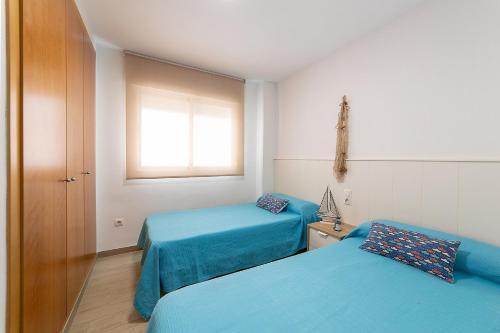 a small room with two beds and a window at Calma Mar in Los Mártires