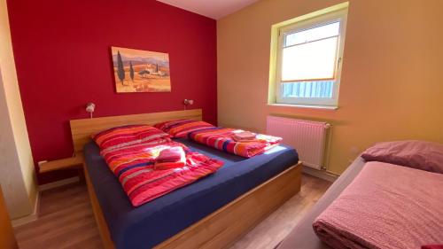 a bedroom with two beds with red walls at Haus Usedom in Kröslin