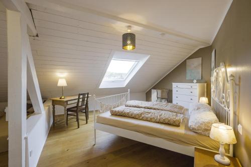 a bedroom with a bed and a desk in a attic at Happy Hugle Haus in Offenburg