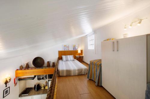 a small bedroom with a bed and a refrigerator at Casa do Campo Dornes Um in Paio Mendes
