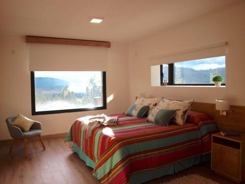 聖馬丁德洛斯安第斯的住宿－Casa de Montaña Golf & Polo - San Martin de los Andes，一间卧室设有一张床和两个大窗户