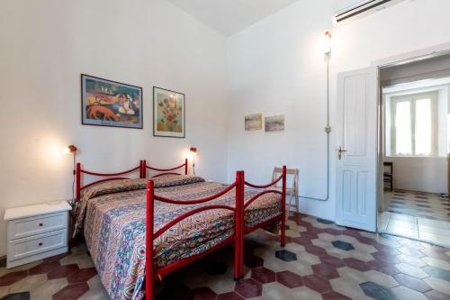 a bedroom with a red bed in a room at Casa Damiano 1935 in Villasimius