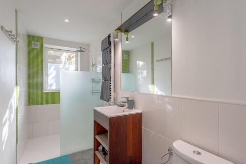 a white bathroom with a sink and a mirror at Gîte Axeri Xilo in Saint-Martin-dʼArrossa