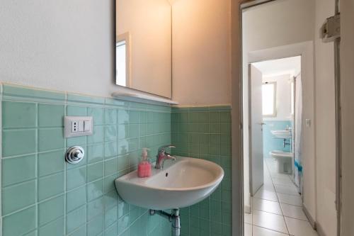 a bathroom with a sink and a mirror at Casa Damiano 1935 in Villasimius