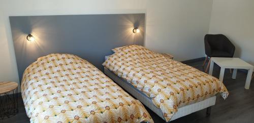 a bedroom with a bed with a comforter on it at Gîte De La Verdurette in Pettonville