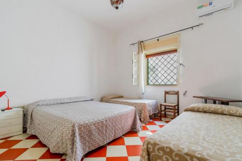 a bedroom with three beds and a window at Villa Cinzia in Torre Lapillo