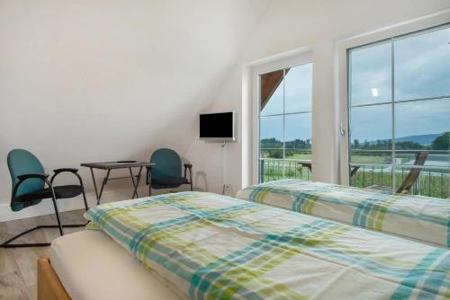 a bedroom with two beds and a table and chairs at Waldsuite in Friedrichshafen