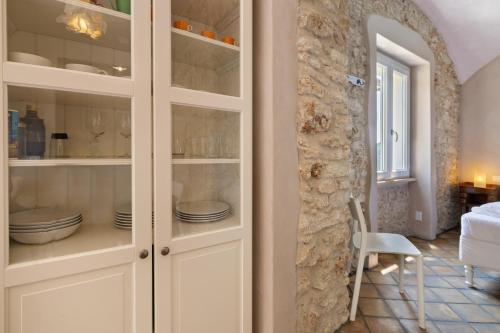 a white cabinet with dishes in it in a room at Casa Virginia - Vigna in Orco Feglino