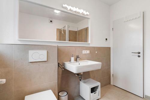 a bathroom with a sink and a toilet and a mirror at Haus 15 in Offenburg