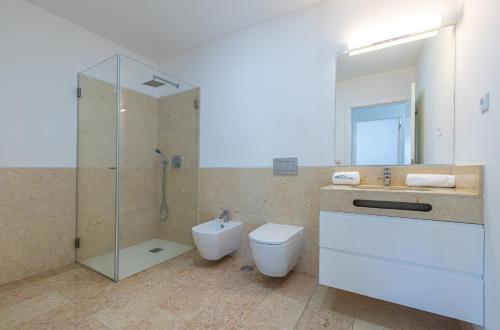 a bathroom with a toilet and a sink and a shower at Forest Village in Azenhas do Mar