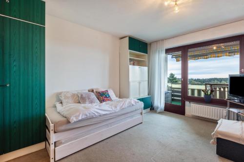 a bedroom with a bed and a large window at Über den Wolken in Höchenschwand