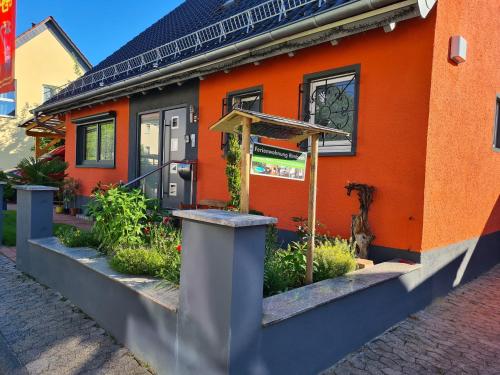 an orange house with a cat sitting outside of it at Ferienwohnung Rimbach in Rimbach