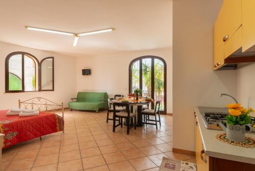 a kitchen and living room with a table and a bed at Monolocale nel centro di Racale in Racale