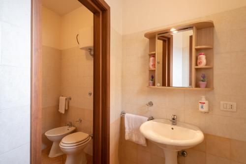 a bathroom with a sink and a toilet and a mirror at Monolocale nel centro di Racale in Racale