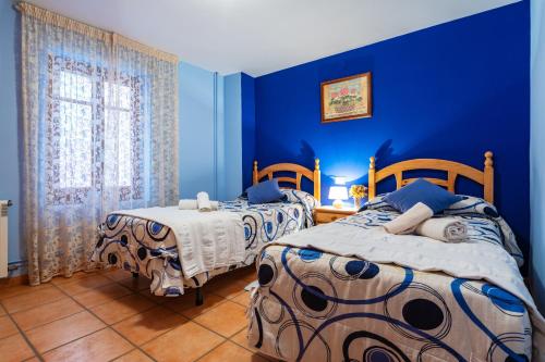 two beds in a room with blue walls at Casa Lino in Culla