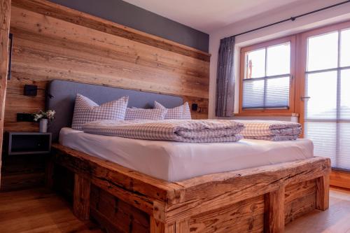 a bedroom with a large bed with a wooden wall at Ferienwohnung Wiagsog in Garmisch-Partenkirchen