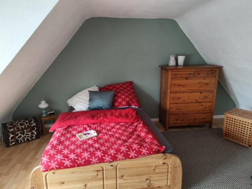 a bedroom with a bed with a red comforter at Ferienunterkunft Göhlich in Maintal