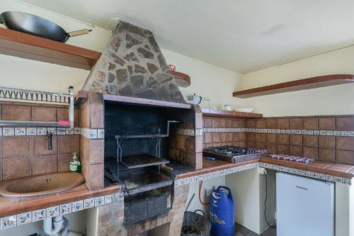 a kitchen with a stone oven and a sink at Vv Terrazita in Tijarafe