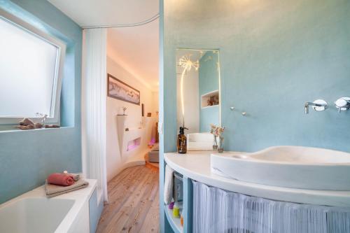 a bathroom with a white tub and a sink at Apartment Belvedere in Caines
