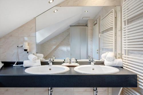 a bathroom with two sinks and a large mirror at Ferienhaus Adler Bellevue in Hinterzarten
