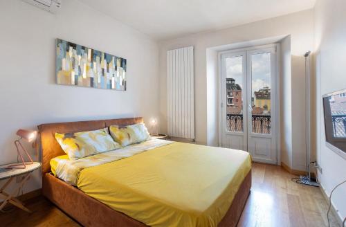 a bedroom with a bed with yellow sheets and a window at Crocetta10 in Milan