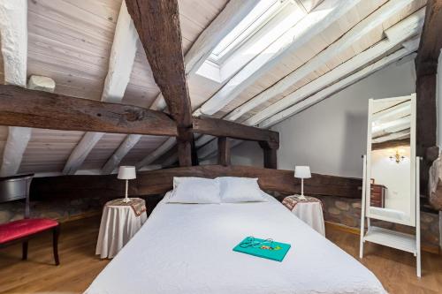 a bedroom with a large white bed with wooden ceilings at Casa Velarde Apto 1 in Viérnoles