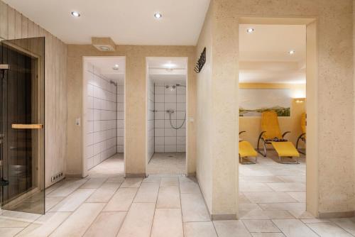 a hallway with a shower and a bathroom with yellow chairs at Fewo Brünnstein - Nr 46 Pool, Sauna in Oberaudorf