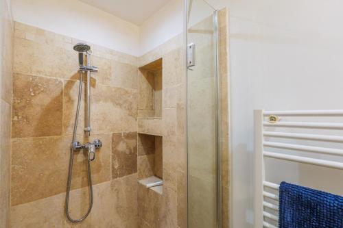 a bathroom with a shower with a glass door at Studio De Caractère Classé 3 in Les Vans