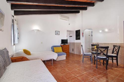 a living room with a bed and a table and chairs at Pedras Del Rei 26 in São Pedro