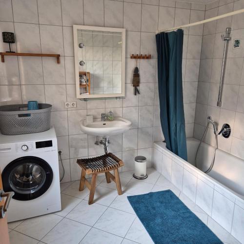 a bathroom with a sink and a washing machine at Ferienwohnung Kleine Pause in Emmendingen