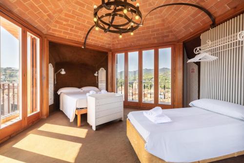 two beds in a room with windows and a chandelier at Villa La Guaita in Ríudecañas