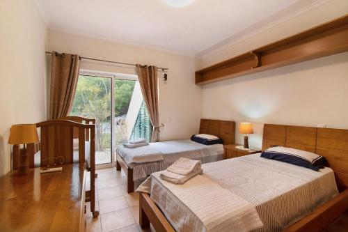 a hotel room with two beds and a window at Vilamoura Tenis 58 in Quarteira